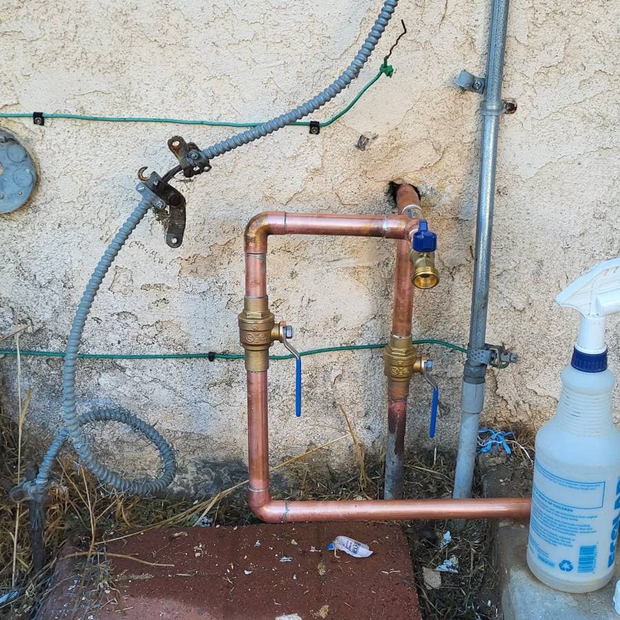 Copper piping repair showing new soldered joints and pressure testing