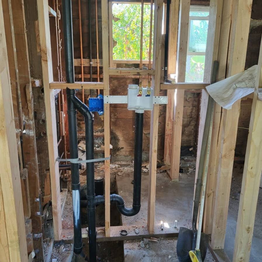 Residential framing showing newly installed plumbing lines and fittings during remodel